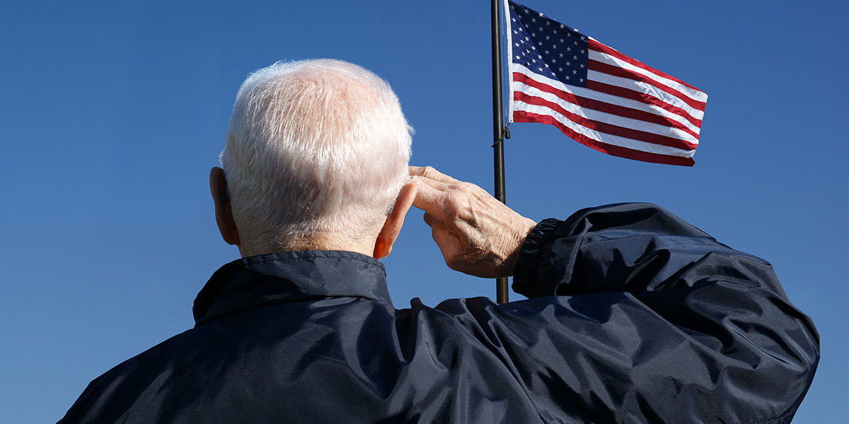 senior veteran saluting american flag struggling with substance abuse in veterans