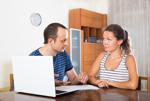 Couple at desk with papers and laptop