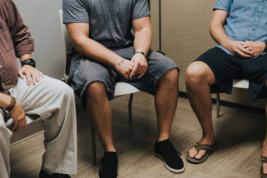 Male patients sitting in a Beaches Recovery alcohol addiction rehab center group therapy session