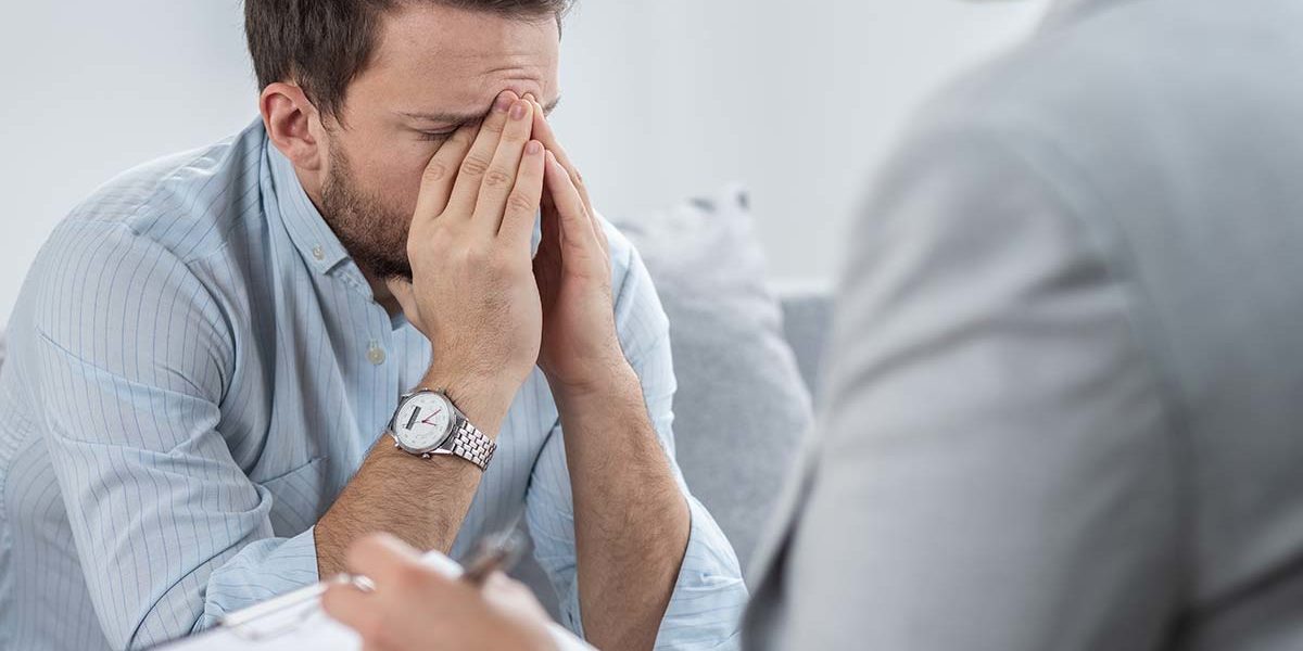 man with hands over his face consulting therapist about executive drug detox programs