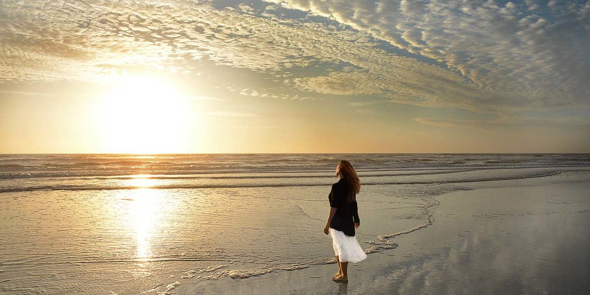 woman watching the sunset at the beach after a Jacksonville addiction treatment program
