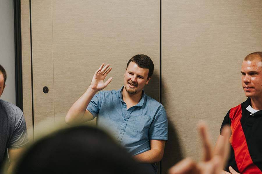 Patients raising their hands during a drug rehab group therapy session