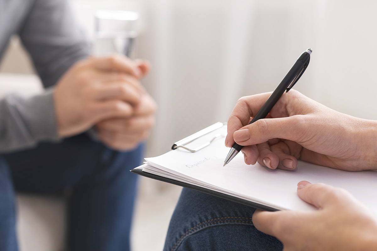 therapist taking notes on drug abuse habits of patient