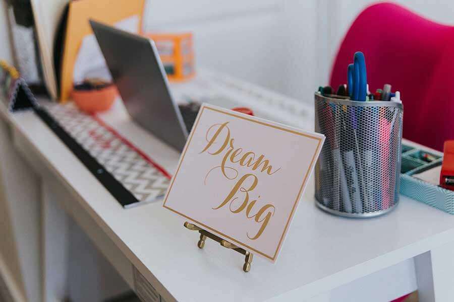 Sign that says Dream Big on an office desk
