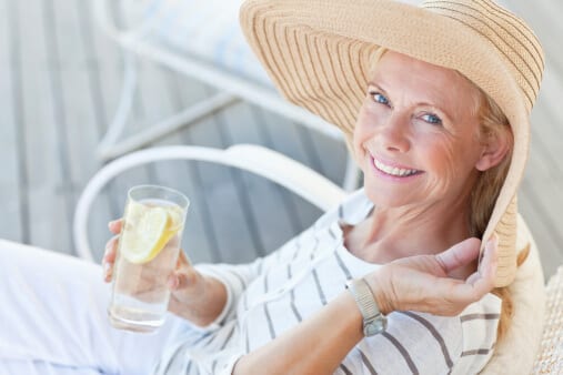 woman in sunhat drinking water at alcohol detox