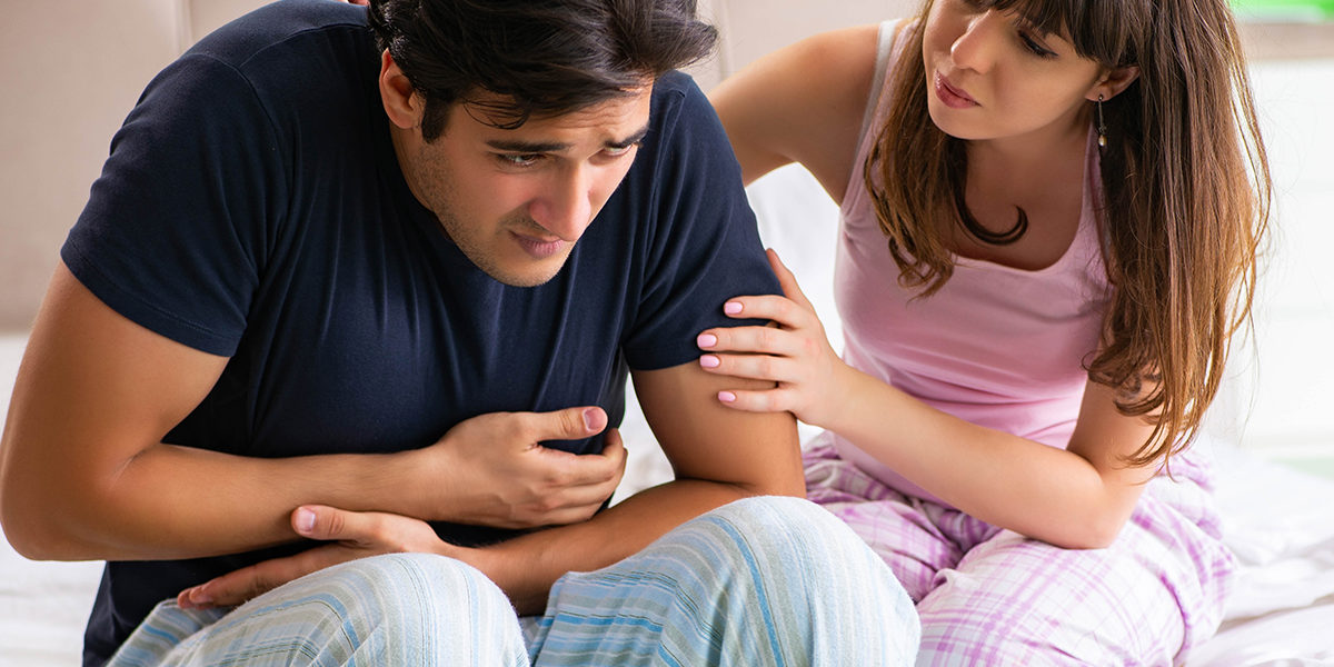 woman holding her sick husband thinking my husband drinks too much