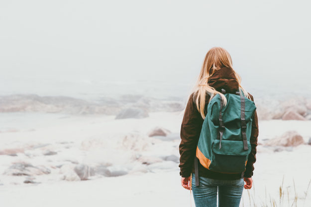 woman backpacking during the stages of addiction recovery