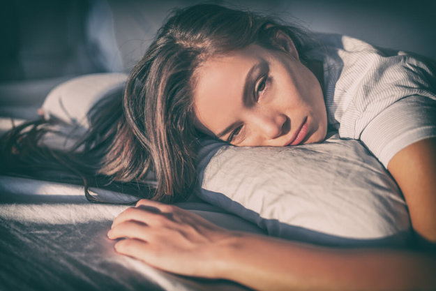 woman laying in bed wondering can you die from heroin withdrawal