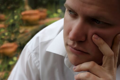 Man in white shirt with finger on face wondering is salvia legal in Florida.