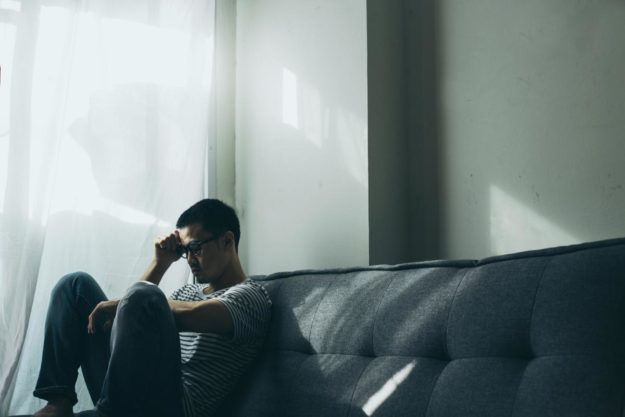 sad man sitting on couch suffering from khat addiction