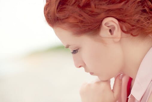 Red-haired woman looking down sad about knowing what is molly.