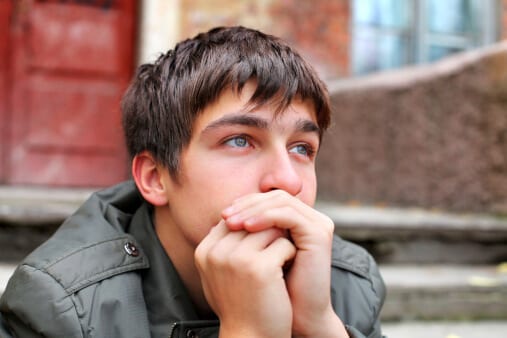 Young man on step looking distracted but knows what is crack.