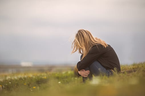 Girl out in field wondering if a Charlotte alcohol rehab center is right for her.