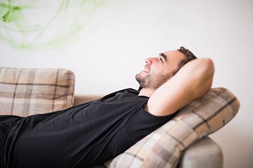 Man laying on sofa comfortable at the best detox center.