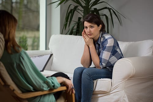 Counselor talking to woman in treatment about the types of therapy they will use.