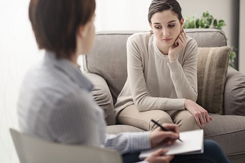 Counselor and young woman engaging in talk therapy during addiction counseling
