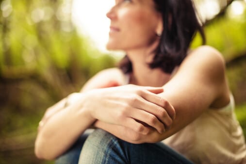 Woman with hand wrapped around knees wondering about alcohol treatment in Florida.