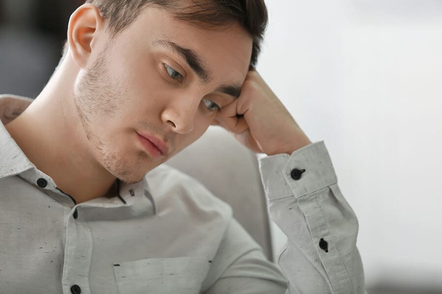 Depressed guy with hand on head probably needs a Florida alcohol detox.