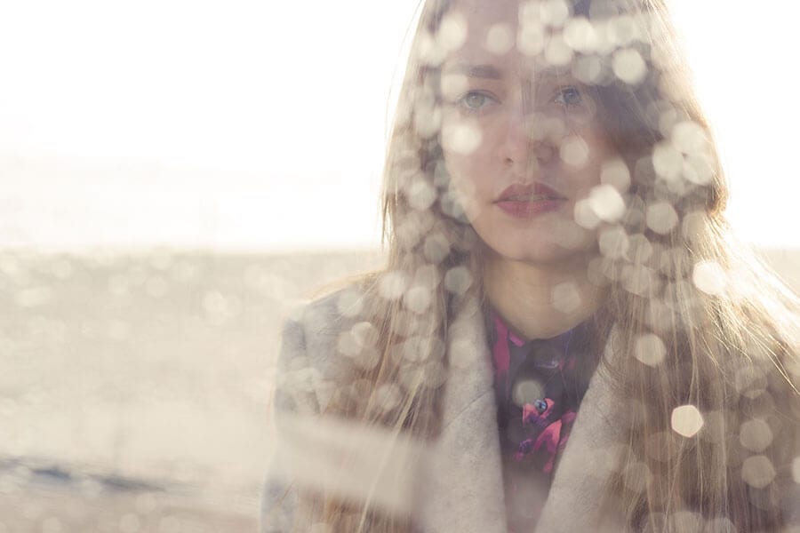 Sad woman through wet window is recovering alcoholic