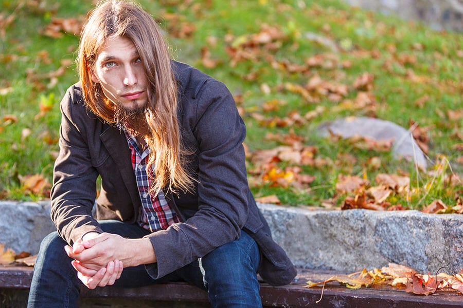 Young long haired man wondering about steroid addiction