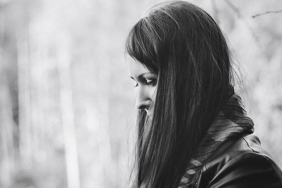 Black and white shot of women looking down, contemplating what to do about stimulant withdrawal.