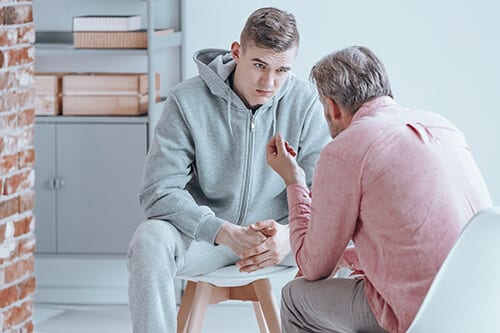 therapist and young man engaging in alcohol abuse counseling