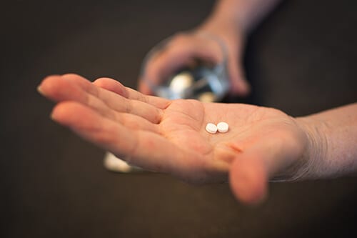 Hand holding pills–why is Ambien dangerous?