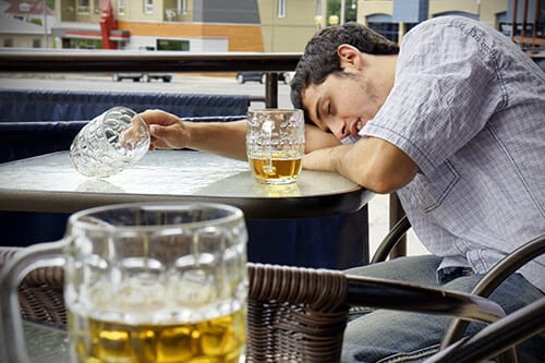 Binge drinking definition sometimes marked by blacking out, like this guy laying head on table.