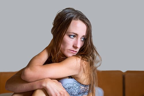 Sad woman on sofa looking for crack addiction treatment