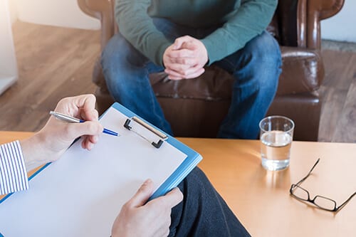 Two people engaging in a substance abuse evaluation before rehab.