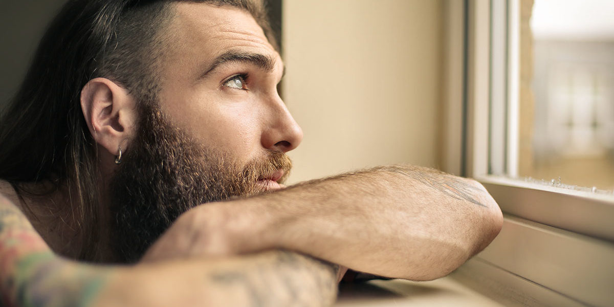 man looking out window needing drug addiction recovery