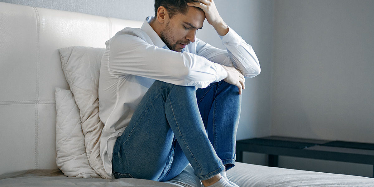 a man holds his head as he struggles with fentanyl side effects