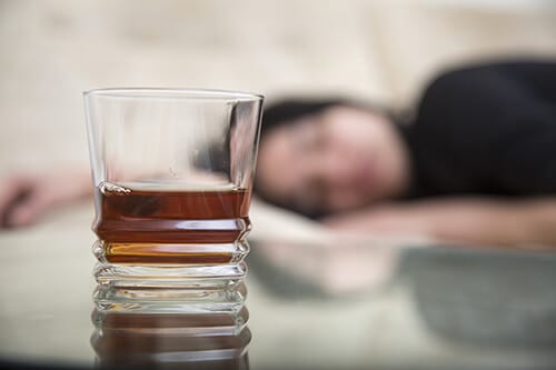 Passed out person in background showing lean drink side effects with lean drink in foreground.