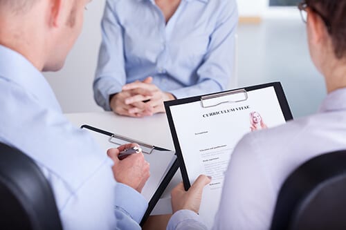 Two faceless clinicians conducting a substance abuse assessment with a third person.