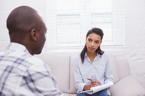 Counselor talking to a man at rehab about to start a transitional living program.