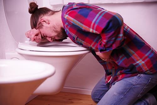 Man hugging the commode definitely has alcohol poisoning symptoms.