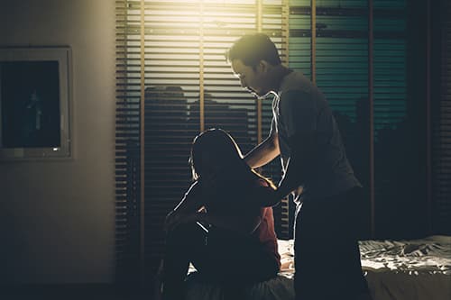 Two people in the dark, male helping female with overcoming dependency.