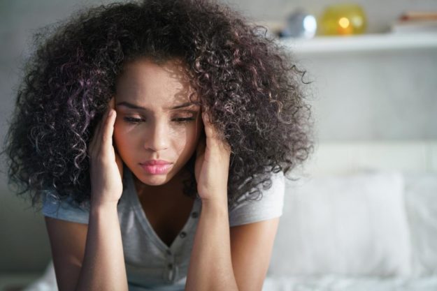 woman holding hands to head after learning what xanax does