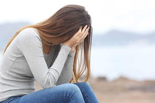 Woman hiding face feeling opium effects that need treatment