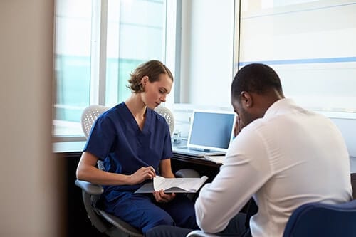 Intake counselor at an medical alcohol detox center talking to upset man