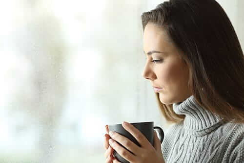 Woman drinking out of mug worried about how to pay for rehab