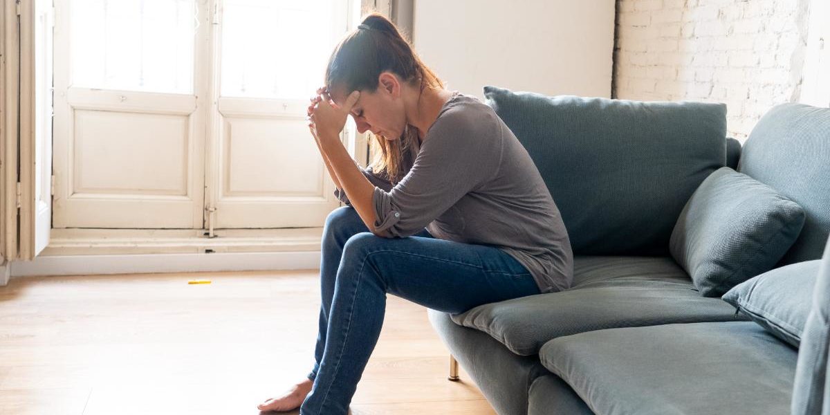 woman struggling and sitting on couch with ketamine high