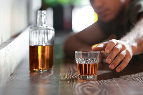 Student reaching for a drink showing binge drinking on college campuses is rampant