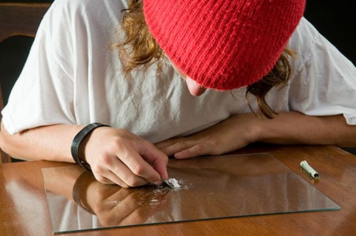 Young person splitting a line of coke may need a Florida drug rehab center for young adults