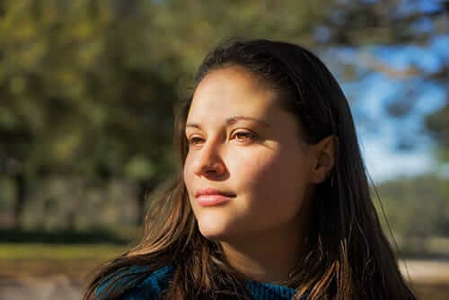 Softly smiling young woman getting through her early recovery from addiction