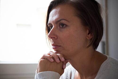 Serious woman wondering about the difference between dbt vs cbt in addiction therapy