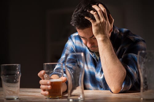 Depressed man at bar does not have to ask do I drink too much