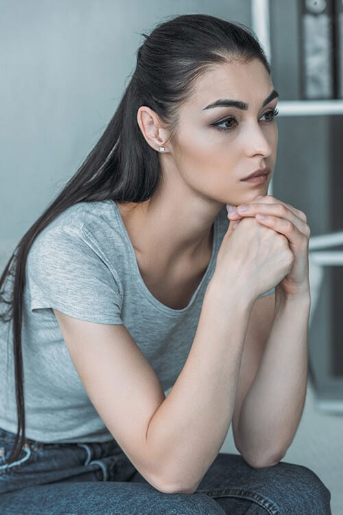 Dark looking woman wondering how long does it take to detox from heroin