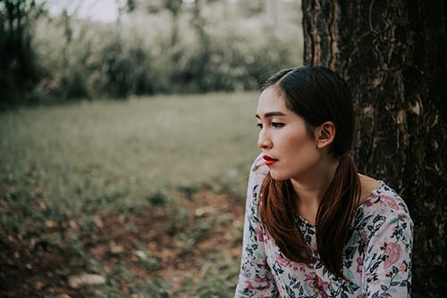 Sad woman worried about how much does drug rehab cost