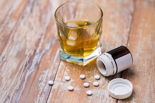 Pills and alcohol on a table during National Drug and Alcohol Facts Week